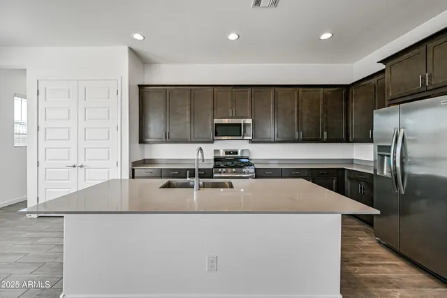 a kitchen with granite countertop a refrigerator and a sink
