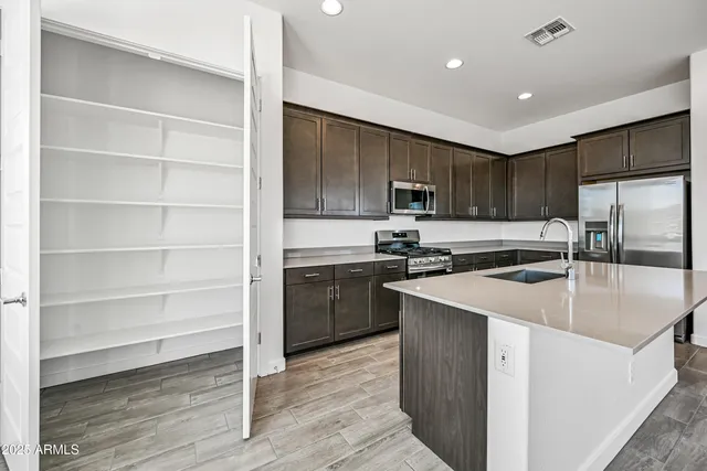 a kitchen with kitchen island a sink stainless steel appliances and cabinets