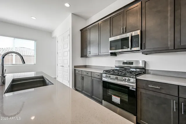 a kitchen with granite countertop a stove and a microwave