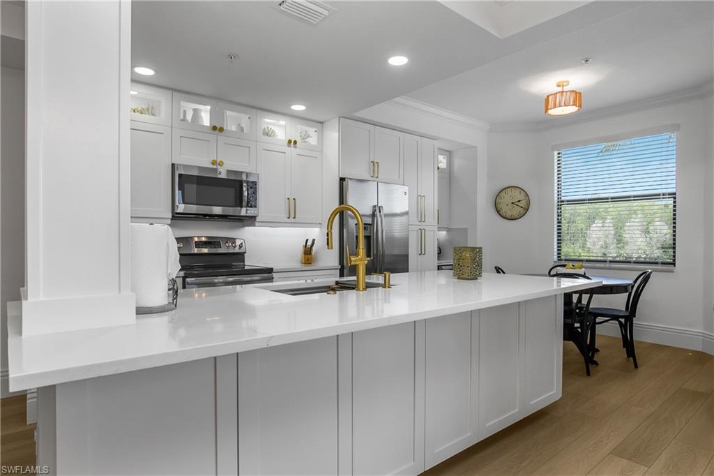 a kitchen with microwave a sink and cabinets