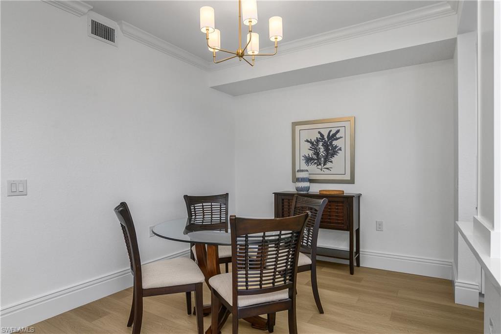 9554 Trevi Court, Unit 4727 Naples, FL 34113 - Photo 15 of 50 a view of a dining room with furniture and wooden floor