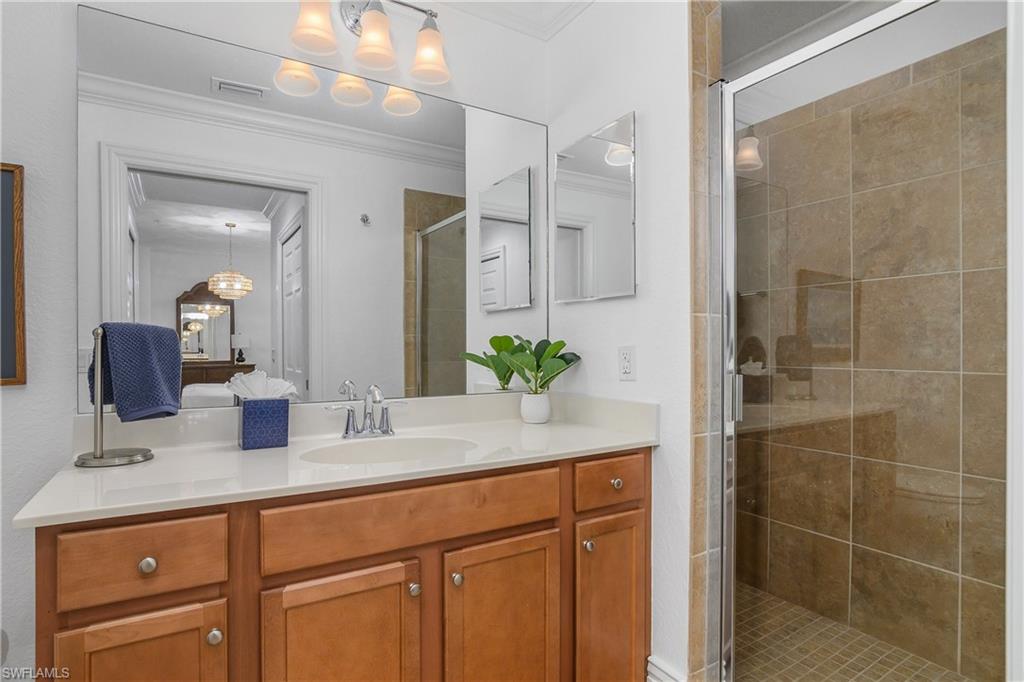 9554 Trevi Court, Unit 4727 Naples, FL 34113 - Photo 20 of 50 a bathroom with a granite countertop sink a mirror and a shower