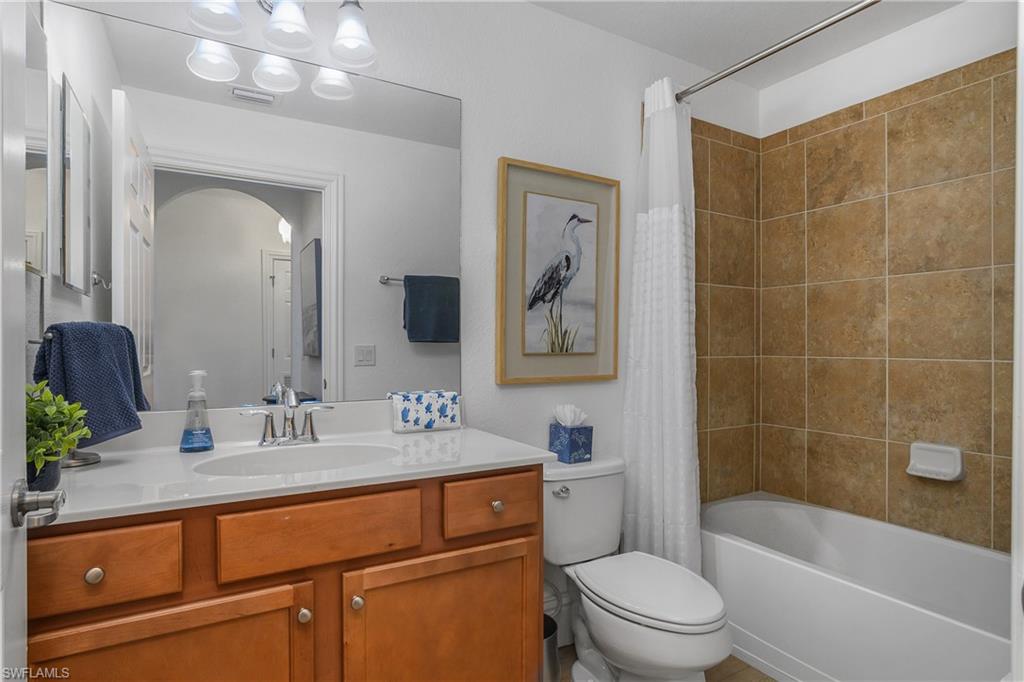 9554 Trevi Court, Unit 4727 Naples, FL 34113 - Photo 23 of 50 a bathroom with a sink a toilet a mirror a vanity and bathtub