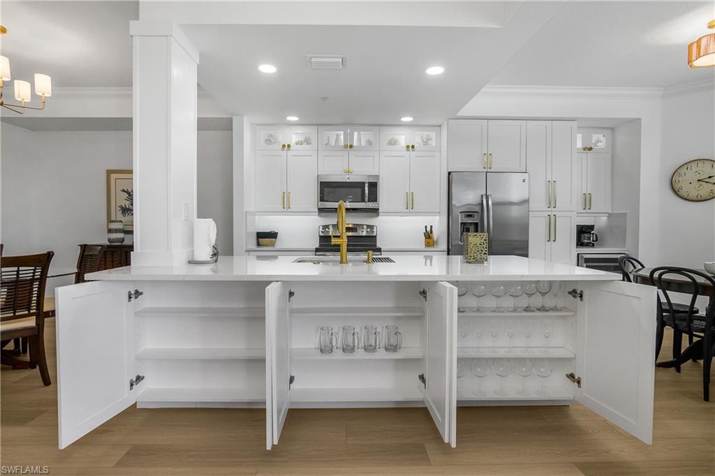 9554 Trevi Court, Unit 4727 Naples, FL 34113 - Photo 25 of 50 a kitchen with kitchen island cabinets and a refrigerator