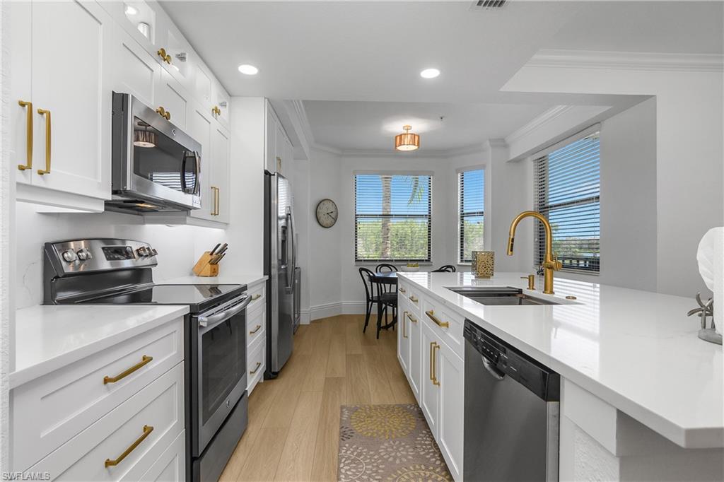 9554 Trevi Court, Unit 4727 Naples, FL 34113 - Photo 4 of 50 a kitchen with stainless steel appliances granite countertop a sink stove and refrigerator