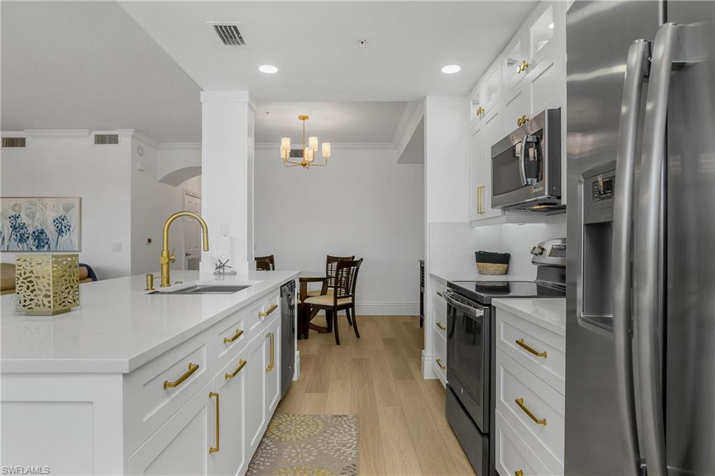 9554 Trevi Court, Unit 4727 Naples, FL 34113 - Photo 5 of 50 a kitchen with stainless steel appliances granite countertop a sink stove and refrigerator