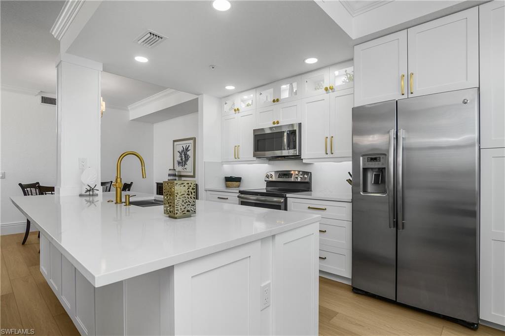 9554 Trevi Court, Unit 4727 Naples, FL 34113 - Photo 6 of 50 a kitchen with refrigerator a sink and cabinets