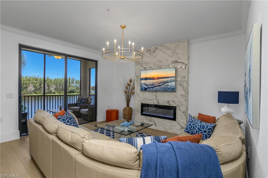 9554 Trevi Court, Unit 4727 Naples, FL 34113 - Photo 9 of 50 a living room with furniture a floor to ceiling window and a flat screen tv
