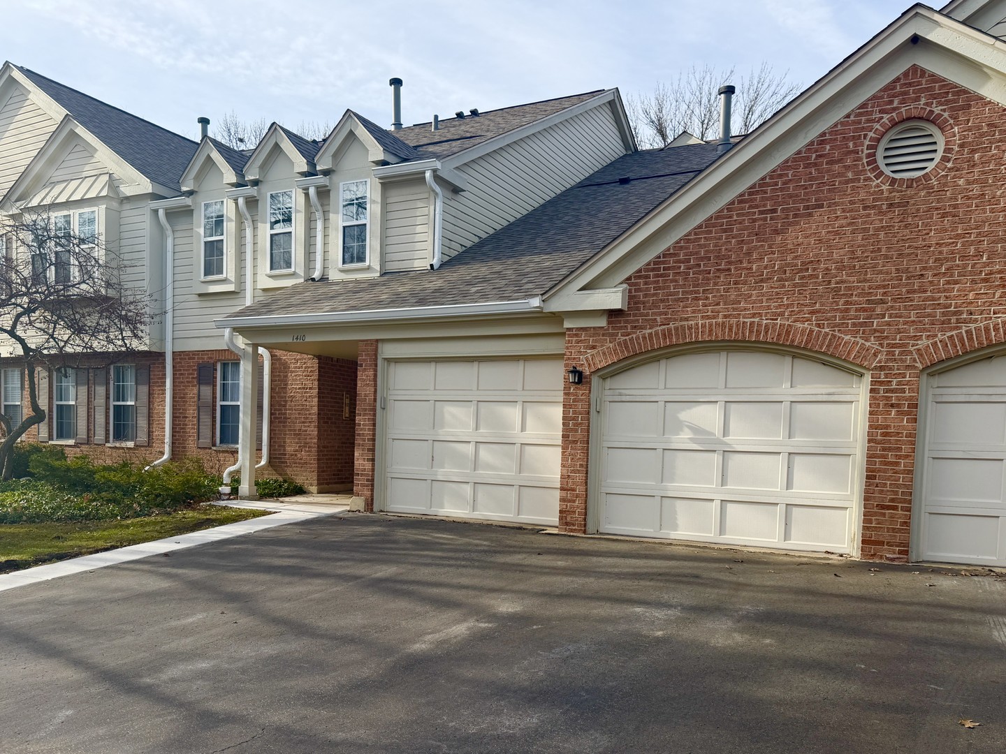 1410 Tulip Court, Unit D2 Wheeling, IL 60090 - Photo 1 of 30 a front view of a house with a yard and garage
