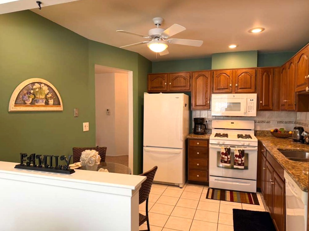 1410 Tulip Court, Unit D2 Wheeling, IL 60090 - Photo 3 of 30 a kitchen with a refrigerator and a stove top oven