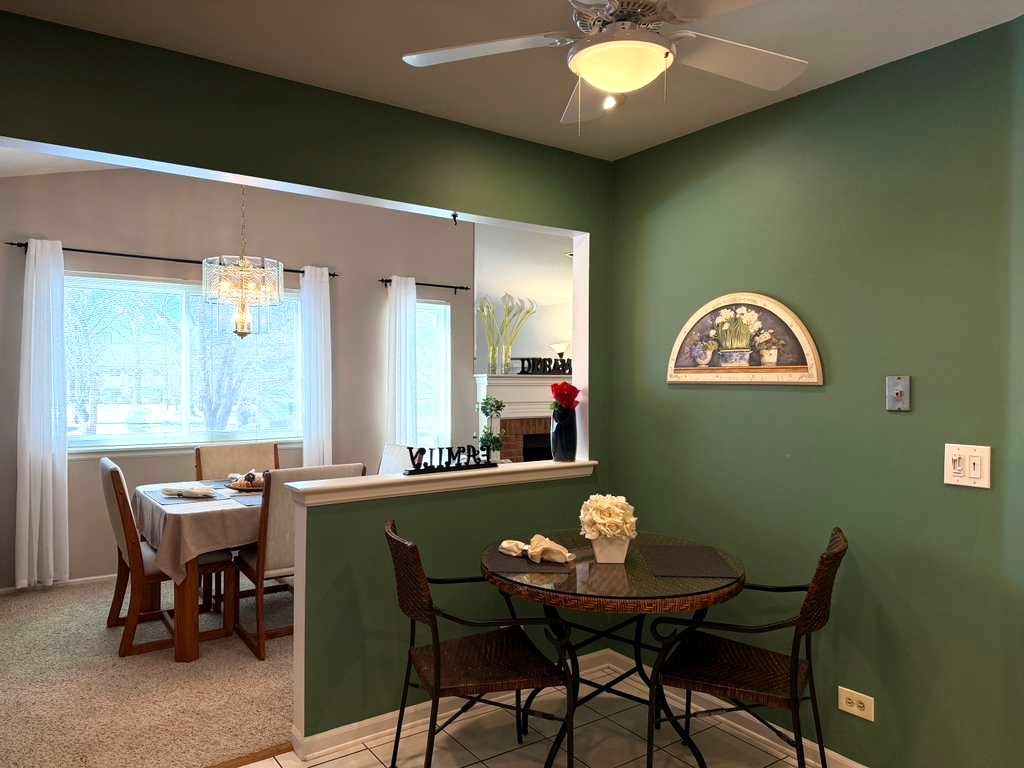 1410 Tulip Court, Unit D2 Wheeling, IL 60090 - Photo 4 of 30 a view of a dining room with furniture and a large window