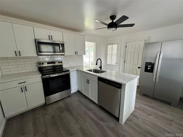 a kitchen with stainless steel appliances kitchen island a sink and a refrigerator