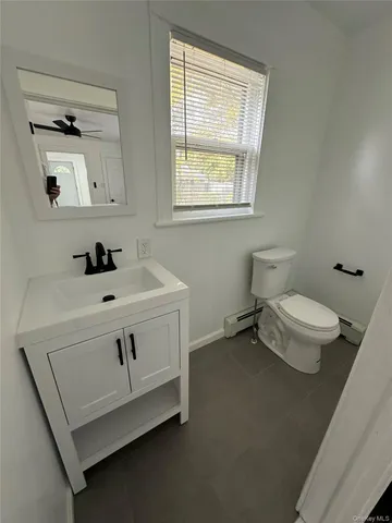 a bathroom with a sink a toilet and window