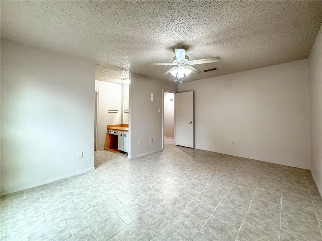 an empty room with a ceiling fan and a window