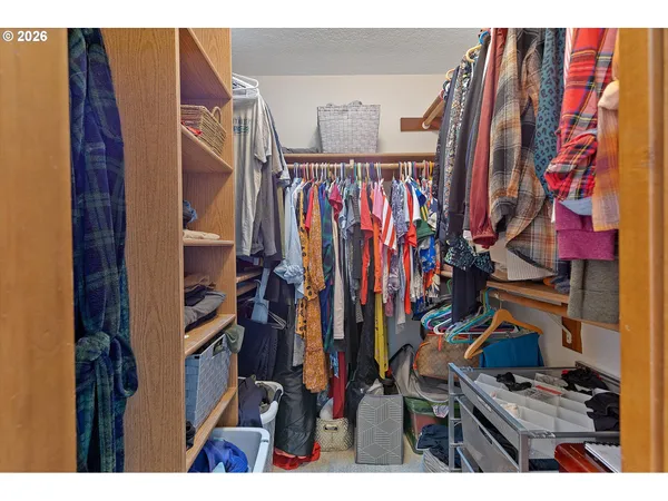 a view of walk in closet with clothes and shoes