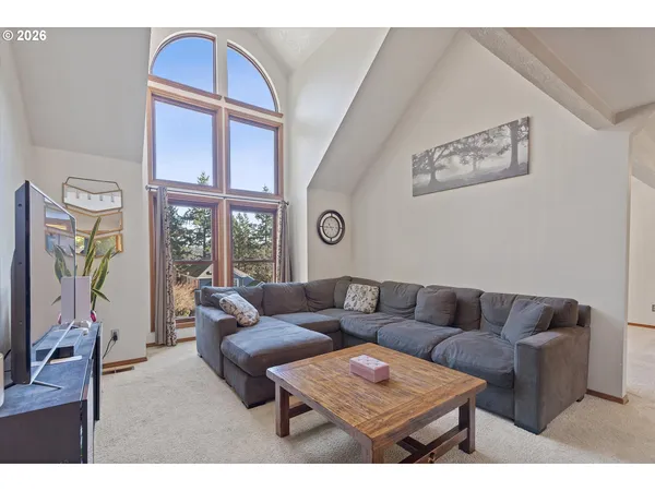 a living room with furniture a rug and a window