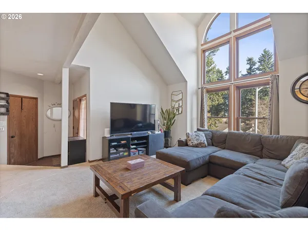 a living room with furniture a flat screen tv and a large window