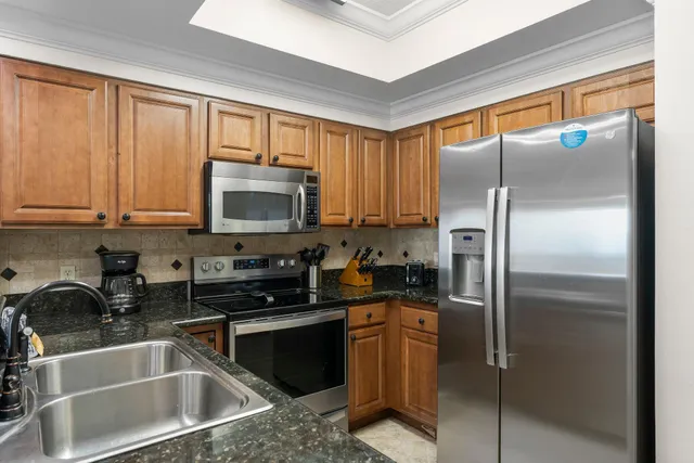 a kitchen with granite countertop a refrigerator and a sink