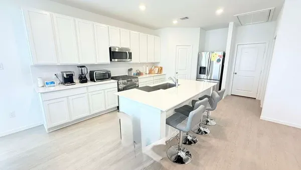 a view of kitchen with sink stainless steel appliances and cabinets