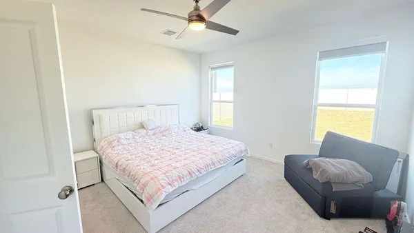 a bedroom with a bed couch and window