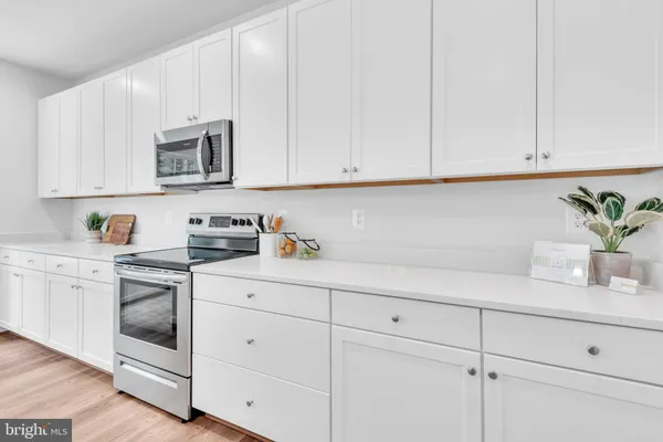 a kitchen with white cabinets and white appliances