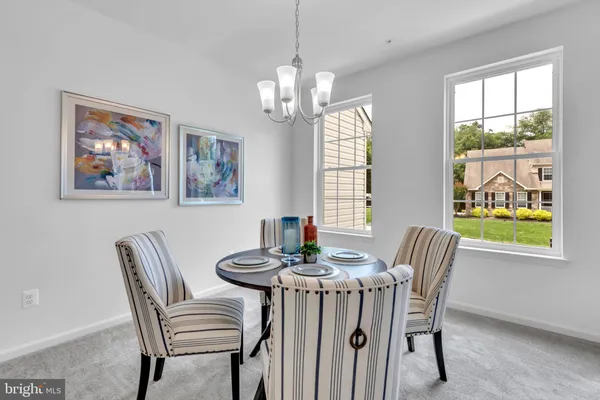 a dining room with furniture a rug and a large window