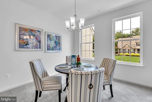 a dining room with furniture a rug and a large window
