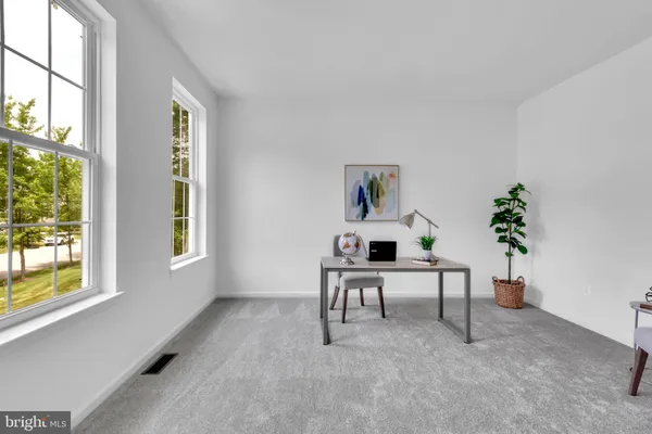 a living room with furniture a potted plant and a window