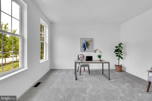 a living room with furniture a potted plant and a window