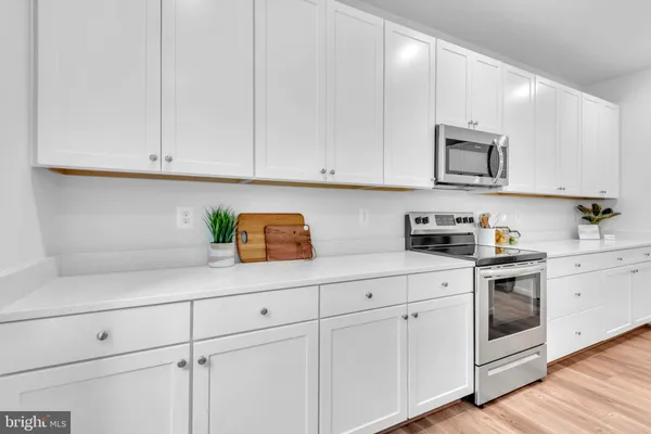 a kitchen with white cabinets and white appliances