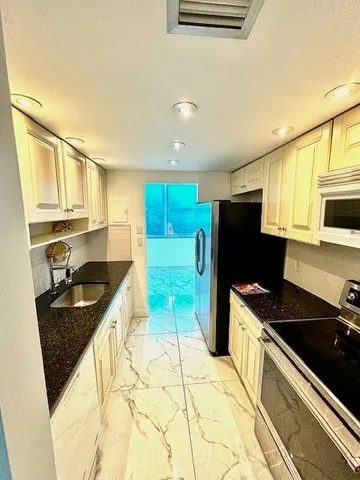 a kitchen with stainless steel appliances granite countertop a refrigerator and a sink