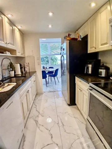 a kitchen with stainless steel appliances a stove a refrigerator and a sink
