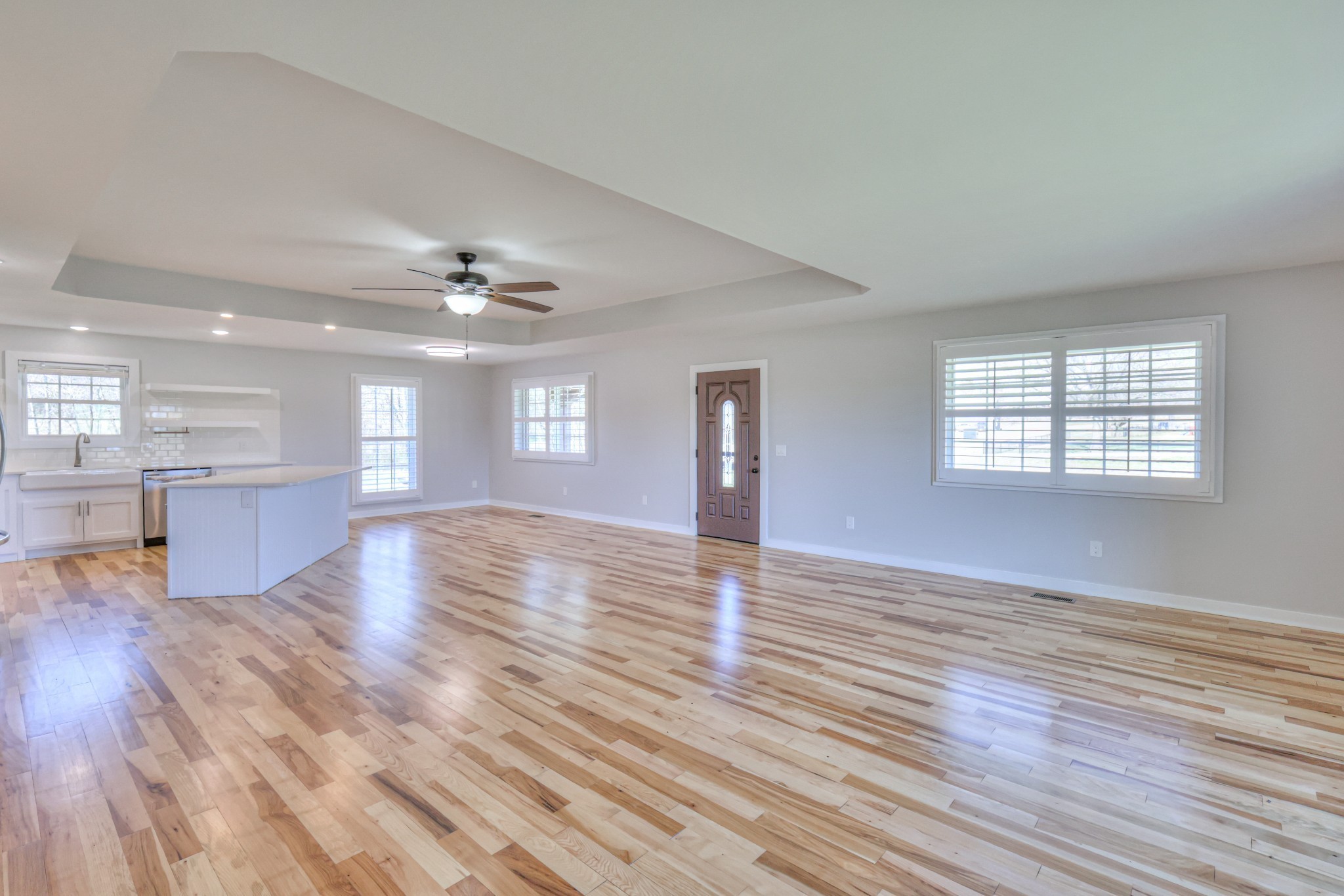 1059 South Cross Bridges Road Mount Pleasant, TN 38474 - Photo 32 of 53 a view of an empty room with wooden floor and a kitchen