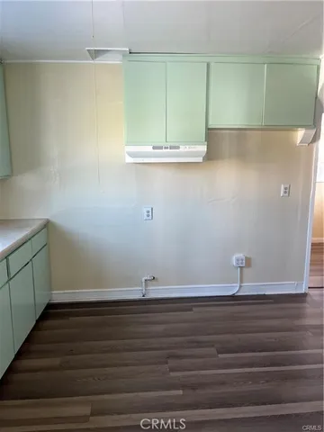 a view of a room with wooden floor and cabinets