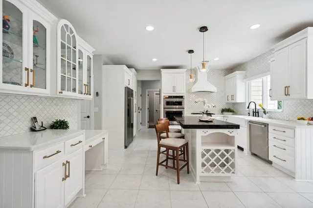 a kitchen with stainless steel appliances kitchen island granite countertop a sink and a refrigerator