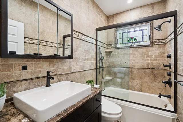 a bathroom with a sink a toilet and shower