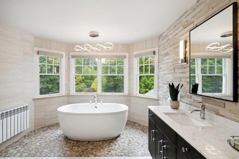 a spacious bathroom with a granite countertop sink and a large window