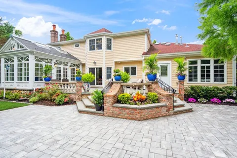 a front view of a house with a garden and outdoor seating
