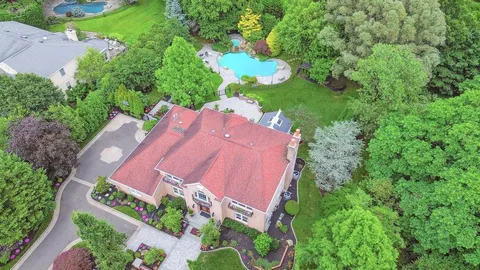 an aerial view of a house with a yard and lake view