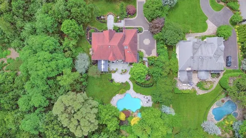 an aerial view of a house with a yard and lake view