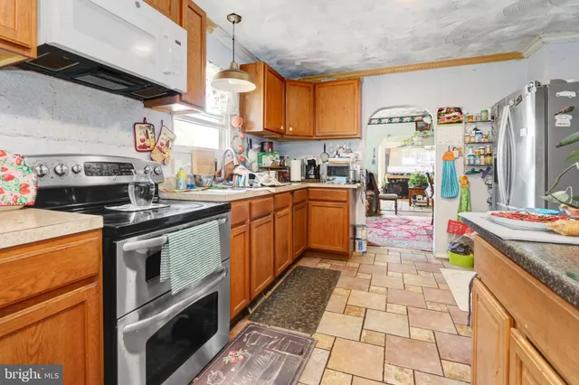 a kitchen with stainless steel appliances granite countertop a stove a sink and a refrigerator