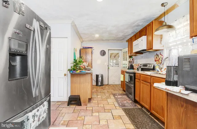 a kitchen with stainless steel appliances granite countertop a refrigerator and a stove