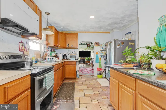 a kitchen with stainless steel appliances granite countertop a stove a sink and a refrigerator