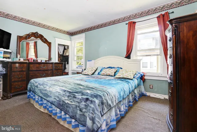 a bedroom with a bed closet and a flat tv screen