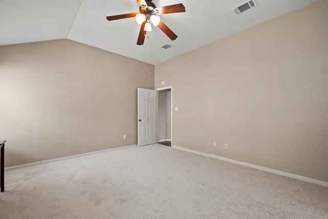 an empty room with closet and a chandelier fan