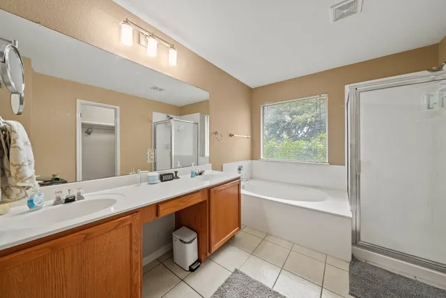 a bathroom with a tub sink and mirror