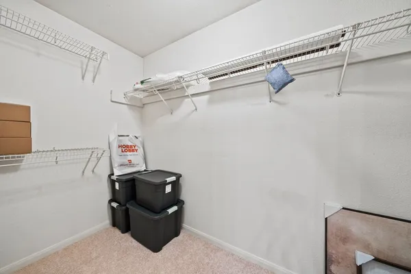 a view of walk in closet with clothes and shoes