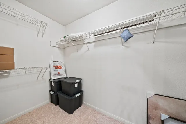a view of walk in closet with clothes and shoes
