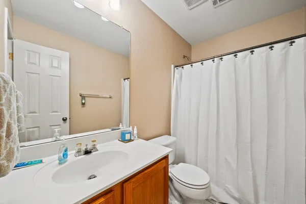 a bathroom with a sink a toilet and shower curtain