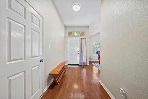a view of a hallway with wooden floor and staircase